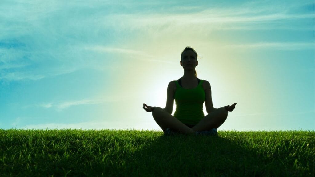 Person-meditating-peacefully-at-sunrise-for-happiness-and-well-being