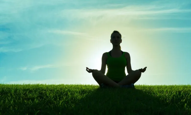 Person-meditating-peacefully-at-sunrise-for-happiness-and-well-being
